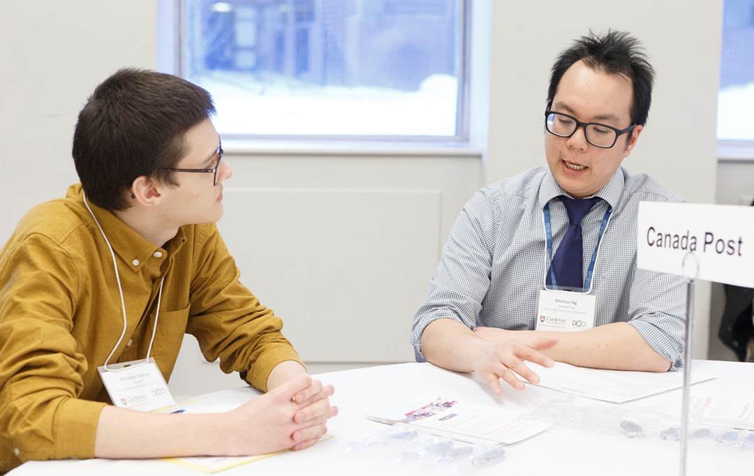 Two attendees discuss accessibility employment.