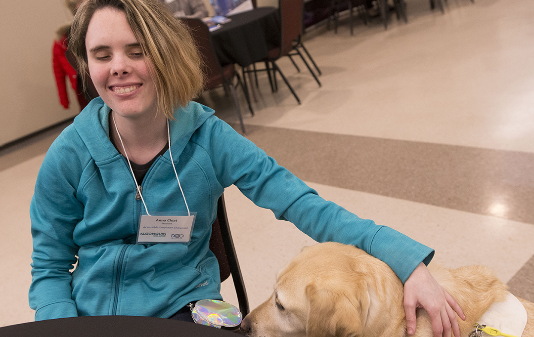 A student sits with her service dog.